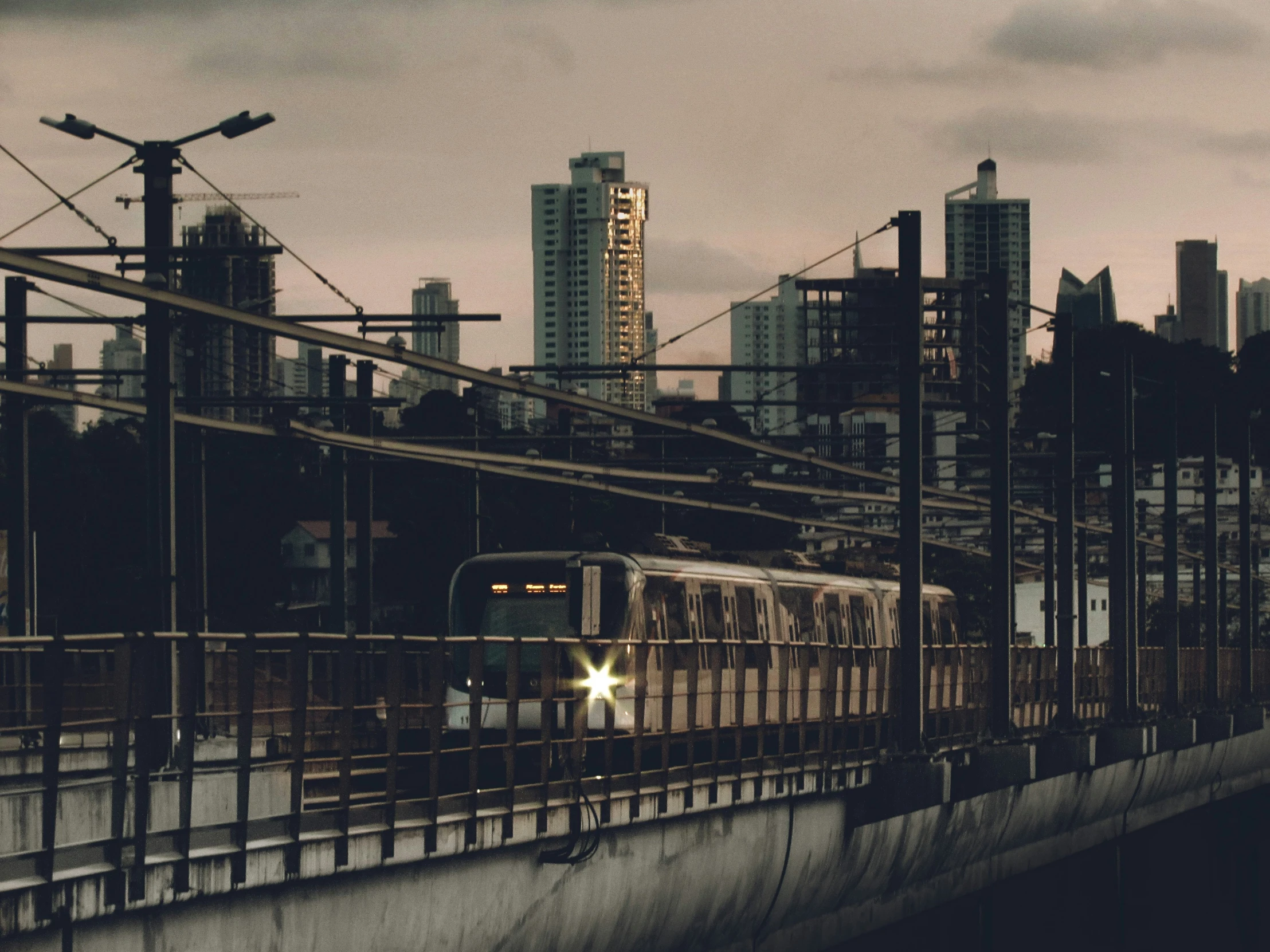 a subway train traveling on a track near a large city