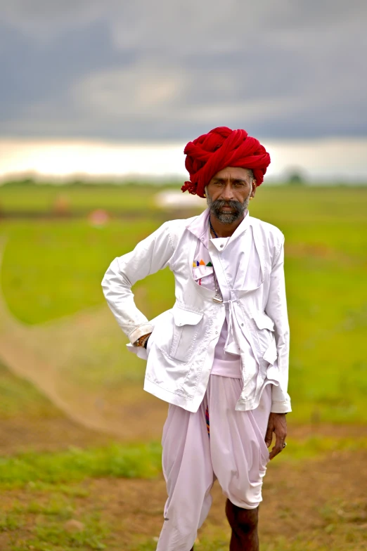 man standing in field with bright clothes and turban