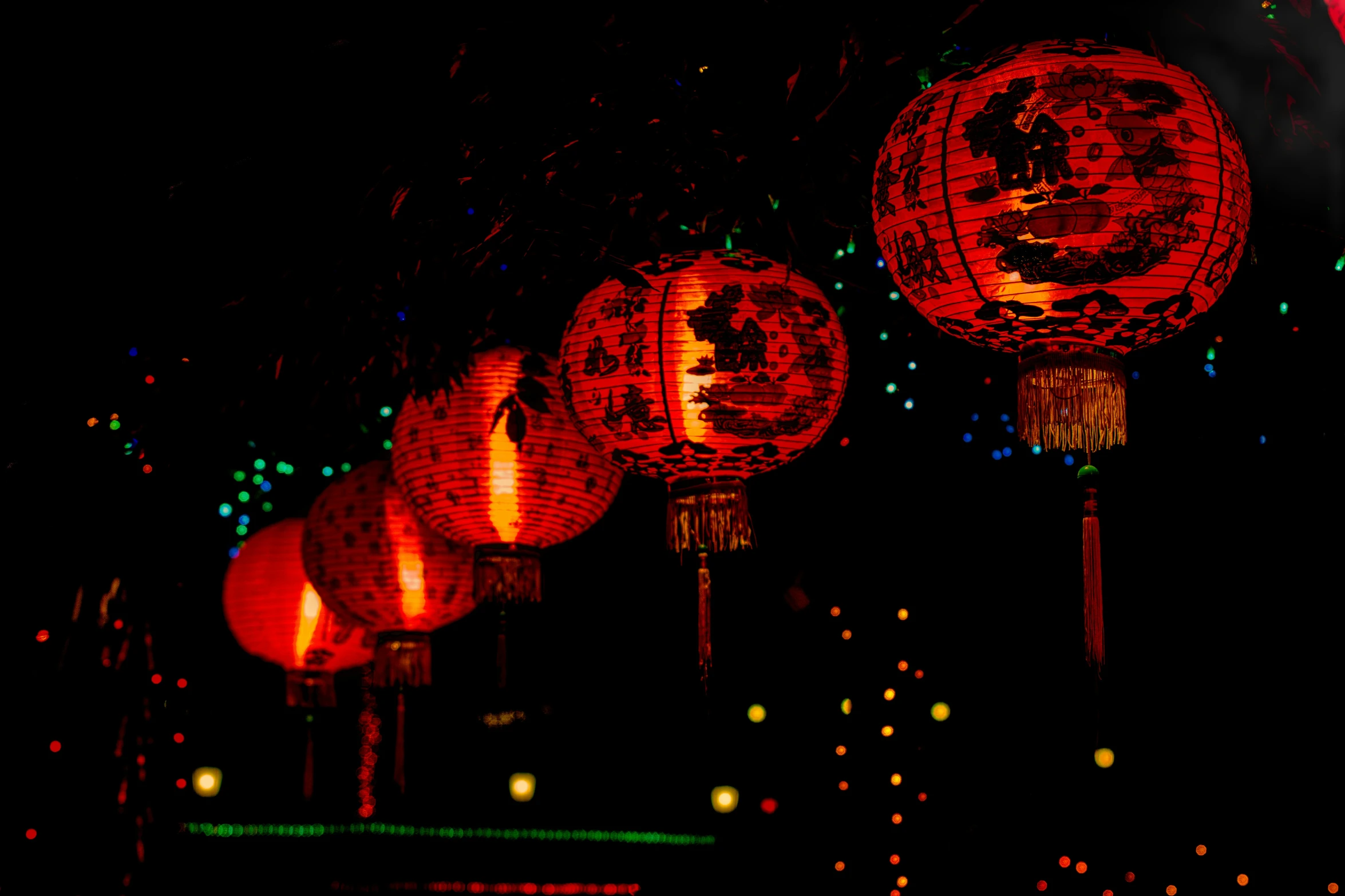 lanterns lit up in red and yellow on a dark night