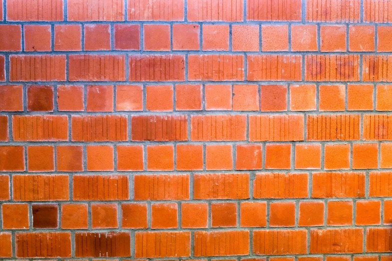 a bird is standing on the ledge in front of a brick wall