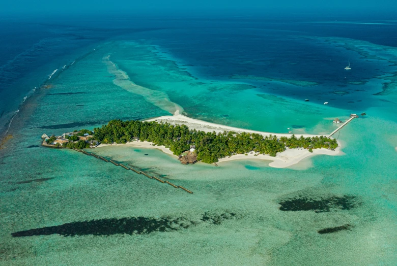 an aerial view of the ocean, island, and reefs of the ocean