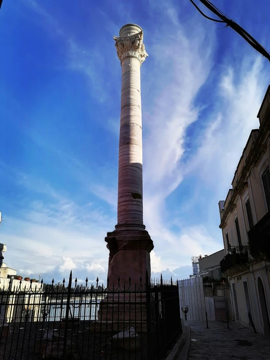 a large column stands in the middle of a stone pavement