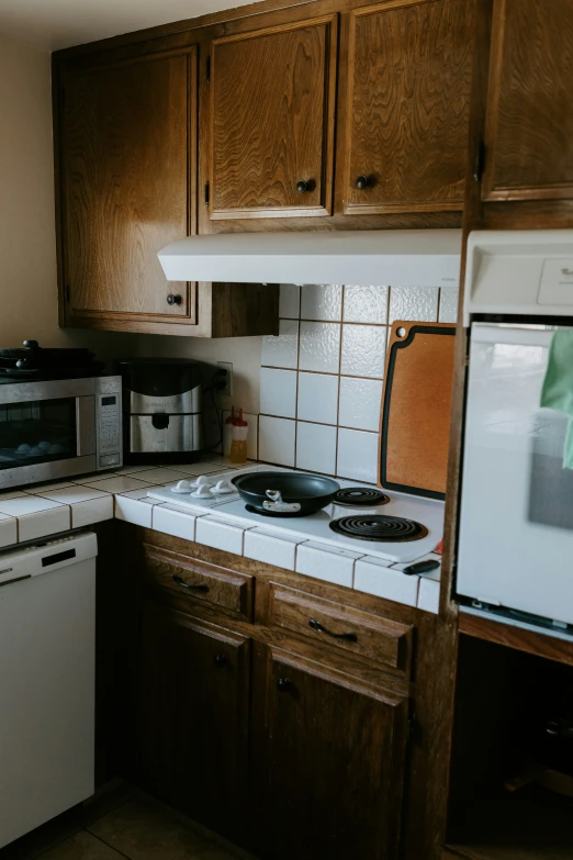 a kitchen has white tiles on the counter top