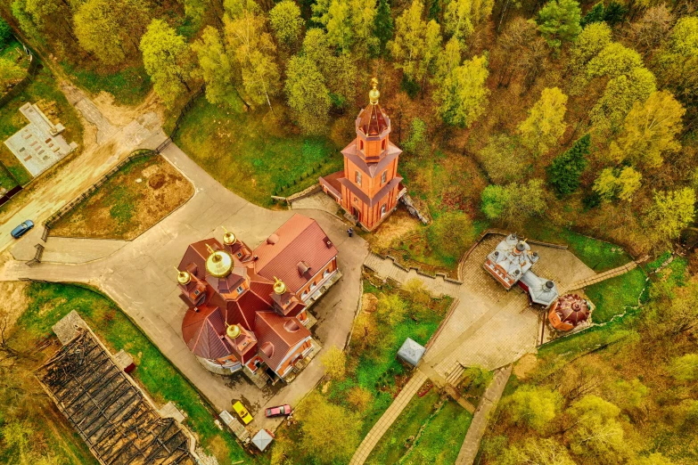 an aerial view of an old country house in the forest