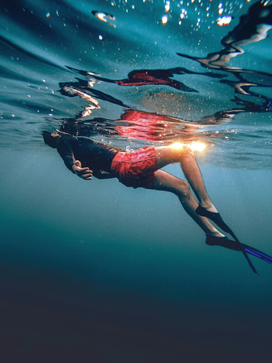 woman with spear underwater, making shadow image