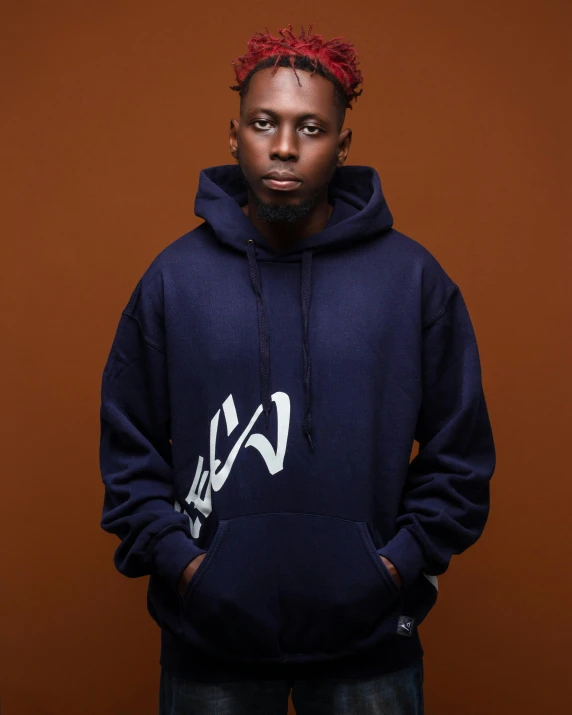 a man standing in front of a brown background