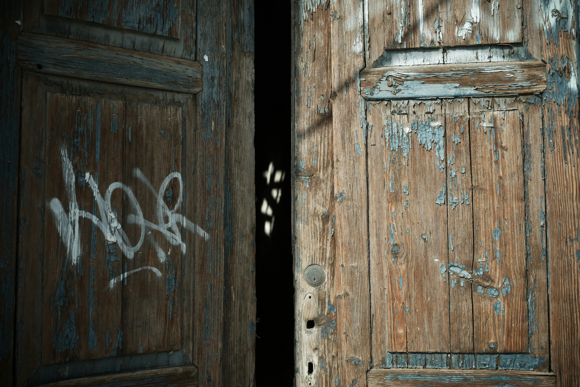 an open wooden door with a graffiti on the outside