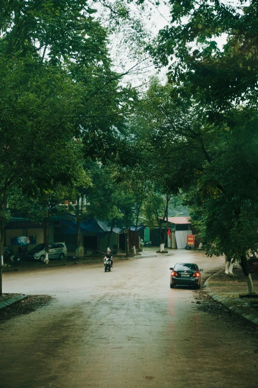 a car driving down a street on a rainy day