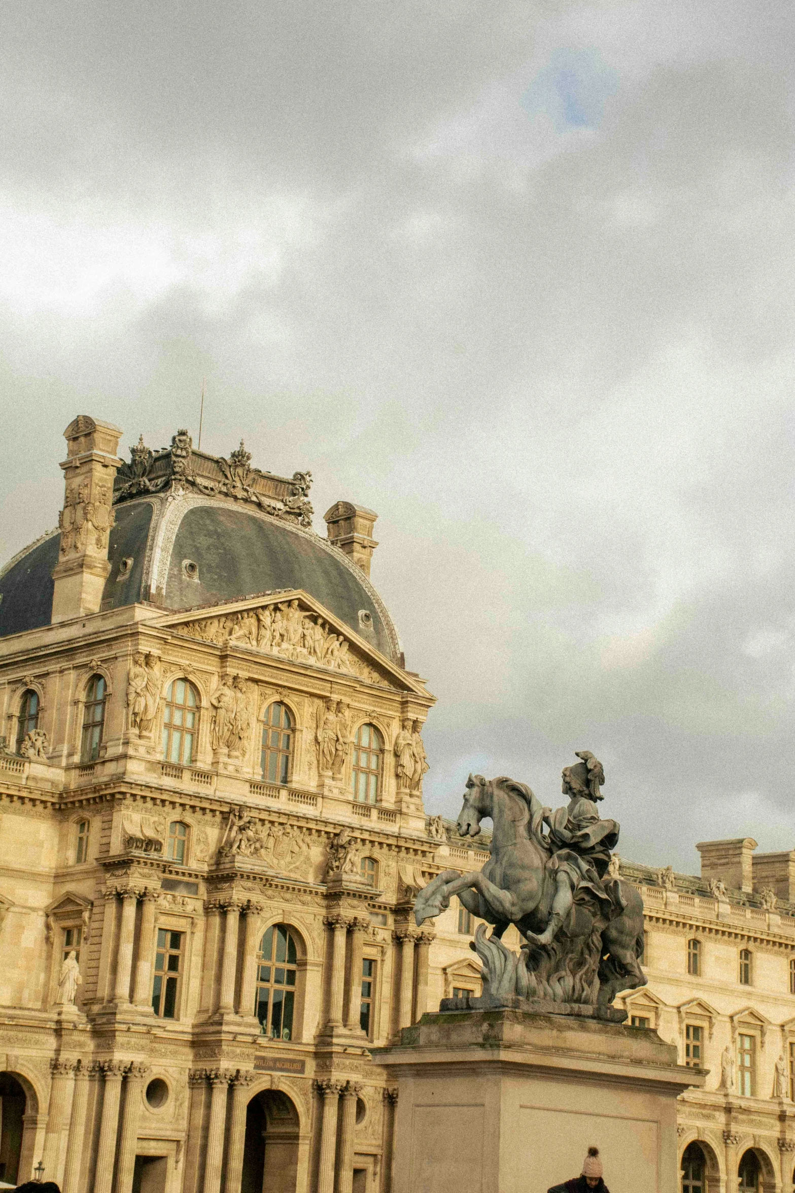 a statue of a man with a horse in front of a building