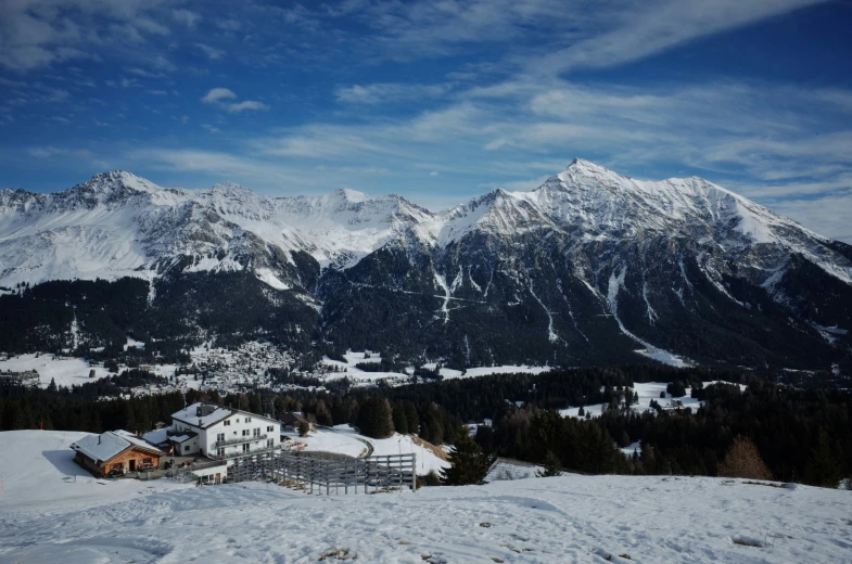 the snow covered mountains and houses in the foreground