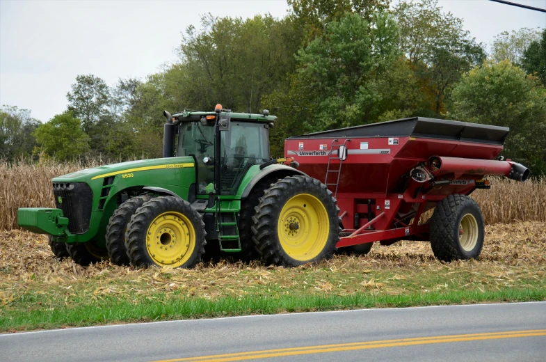 a tractor parked next to a trailer in a field