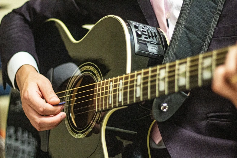 the man is playing on his acoustic guitar