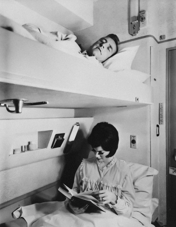 two boys are reading in bunk beds with another boy lying on the bed