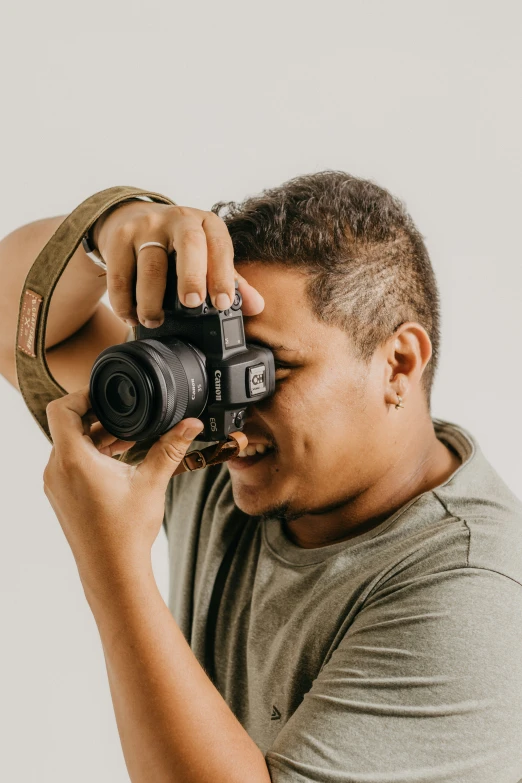 a man is holding a camera up to his face