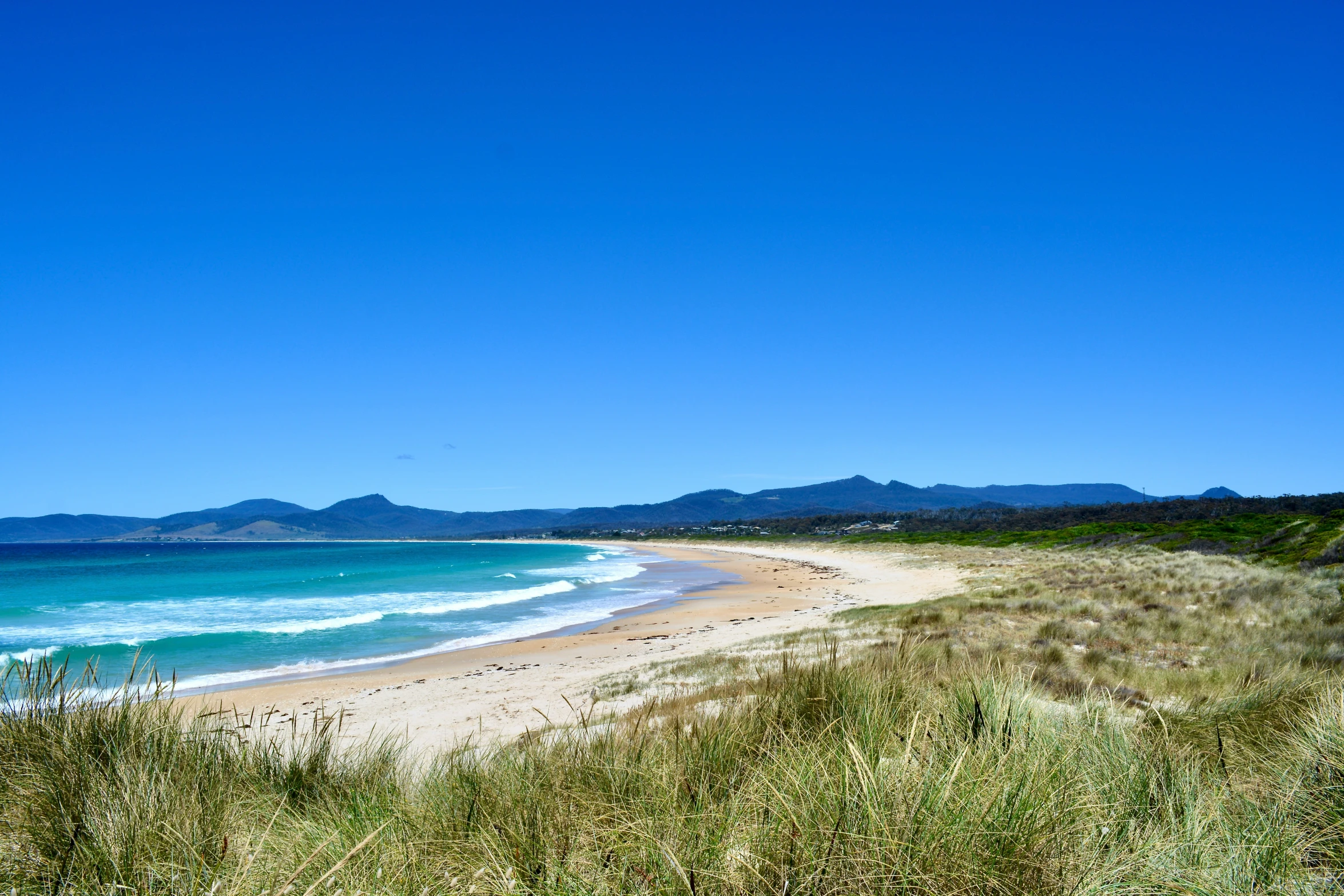 a beautiful beach is seen along a stretch of land