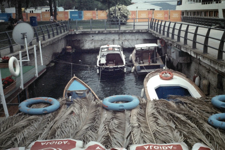 several boats docked near a gate on the river