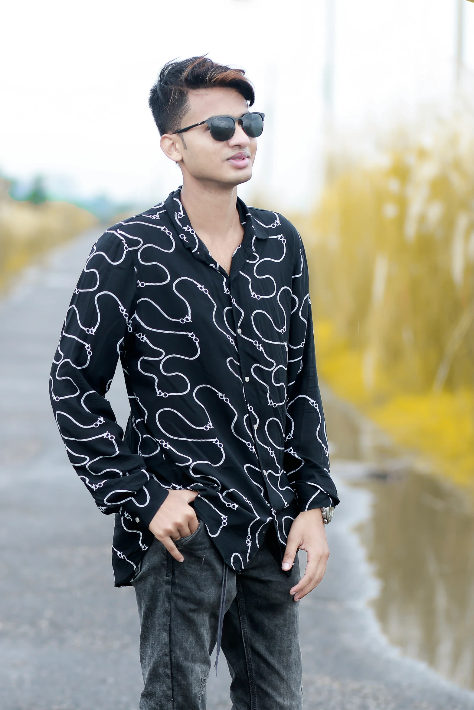 an asian man wearing sunglasses is standing on a road