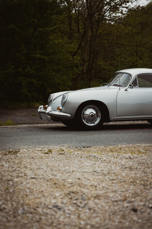 an old car is sitting next to a forest