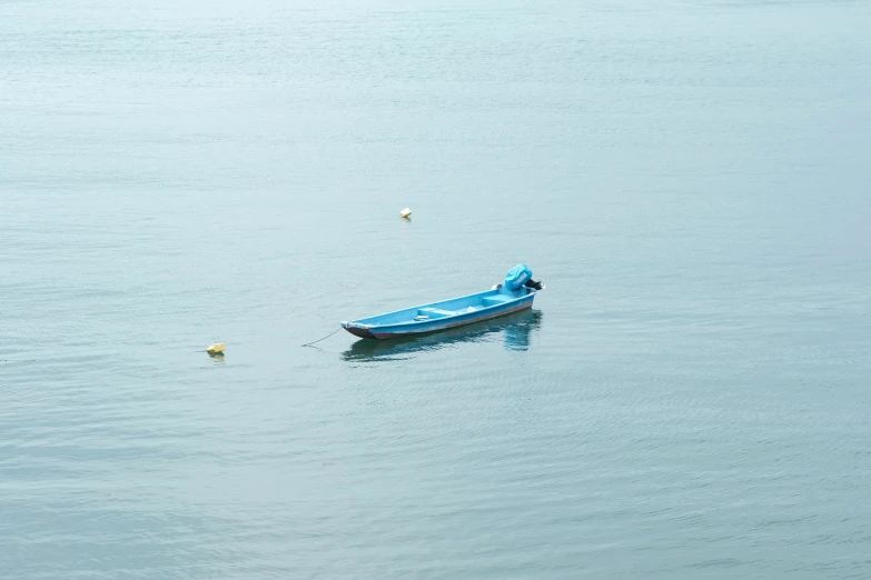 a small blue boat floating on top of a lake