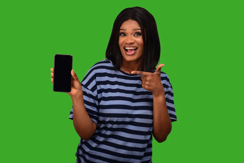 a woman pointing to the camera while wearing a striped shirt