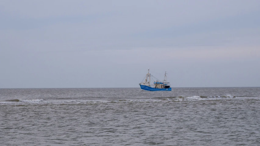 a large boat with blue paint is traveling through the water