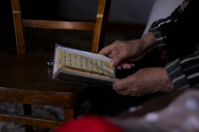 an older person is reading a book and touching it