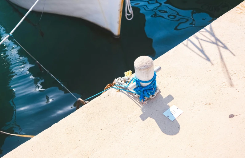 an old hydrant sitting next to the water near some boats