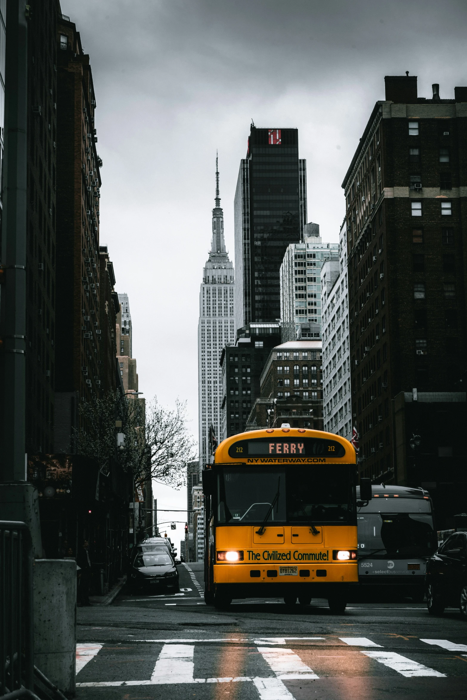 a bus driving down a street past tall buildings