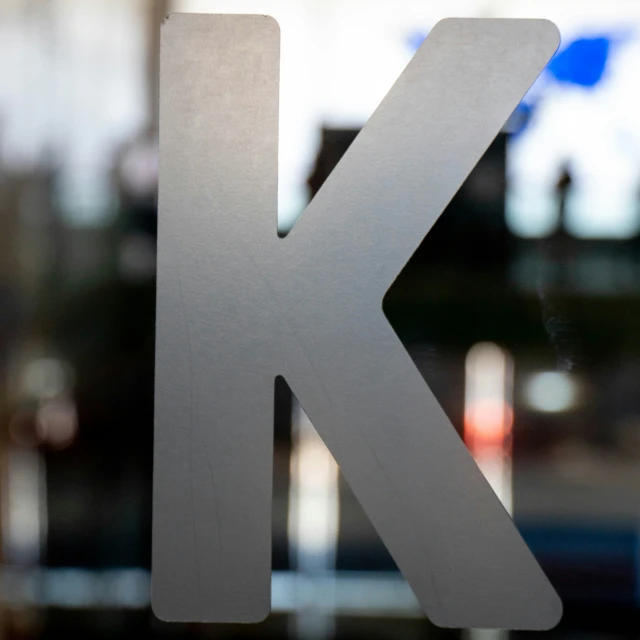 a metal letter k on the side of a glass door