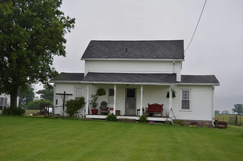 a house with a porch and chairs on the front of it