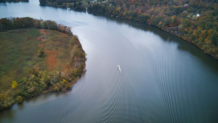 aerial view of boat in a body of water surrounded by forest