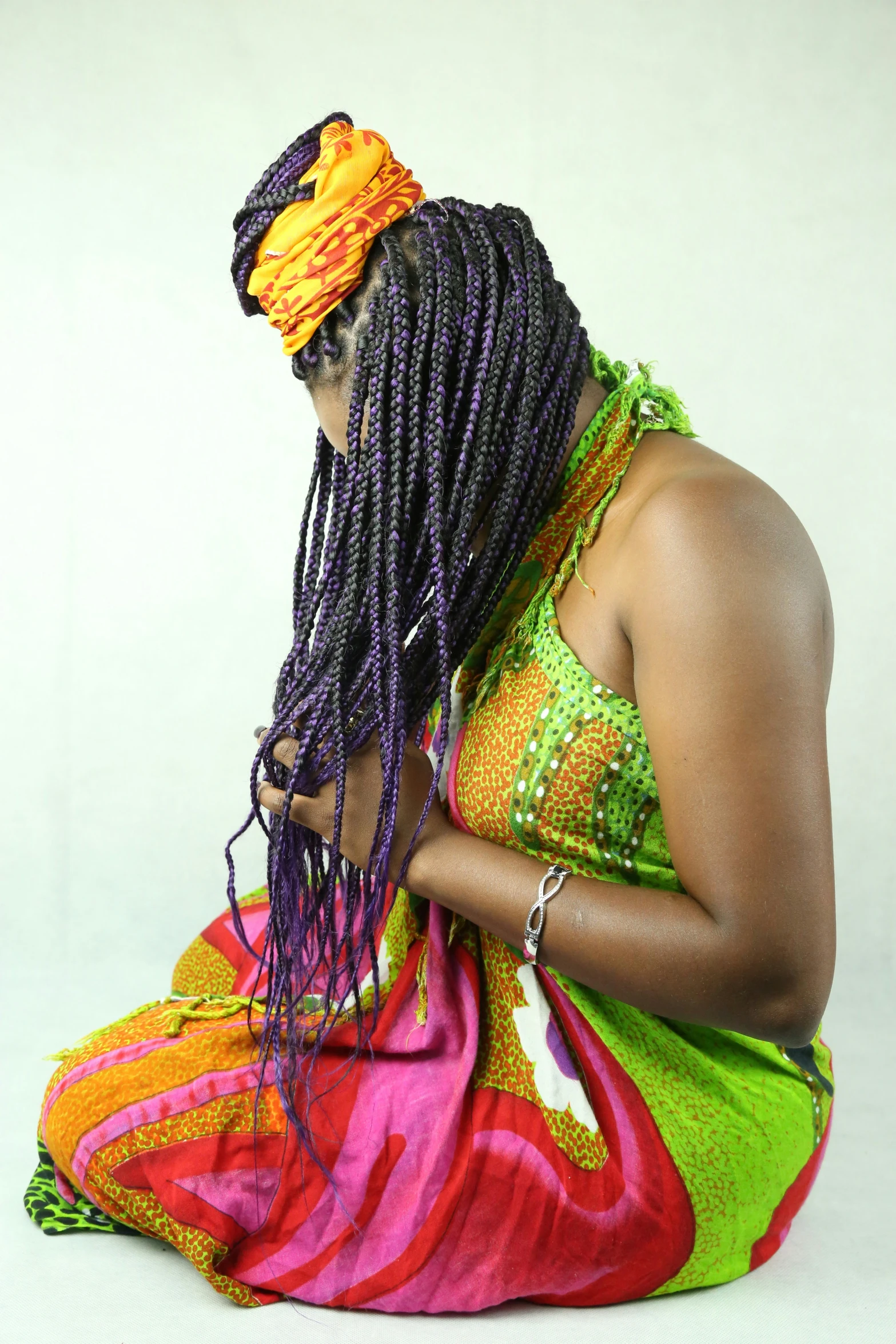 a person with dread locks sitting on the floor