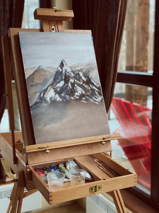 a large easel filled with a picture of snow covered mountains