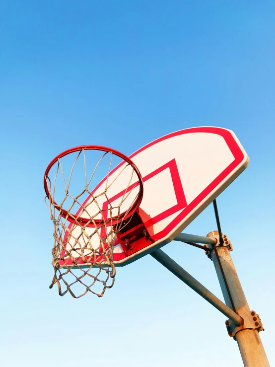 a close up of a basketball hoop with a clear blue sky in the background