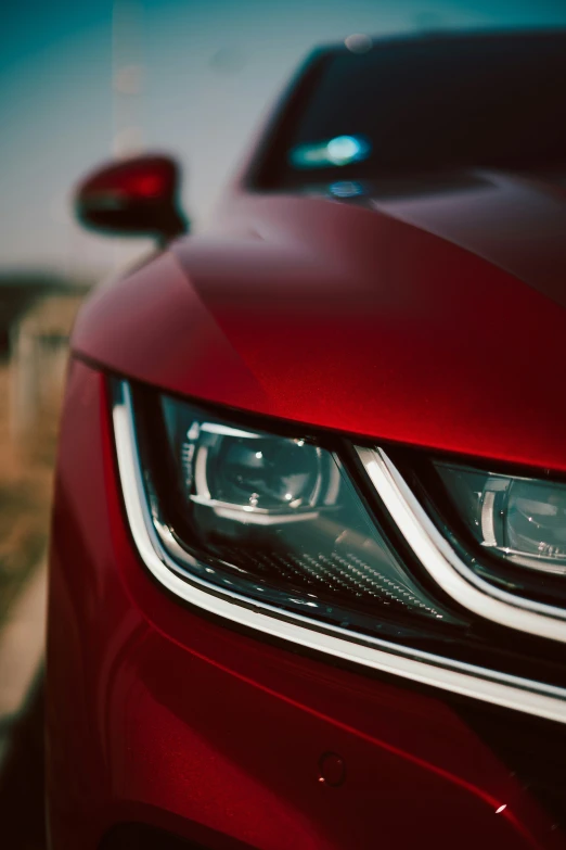 the front end of a red car with chrome trim