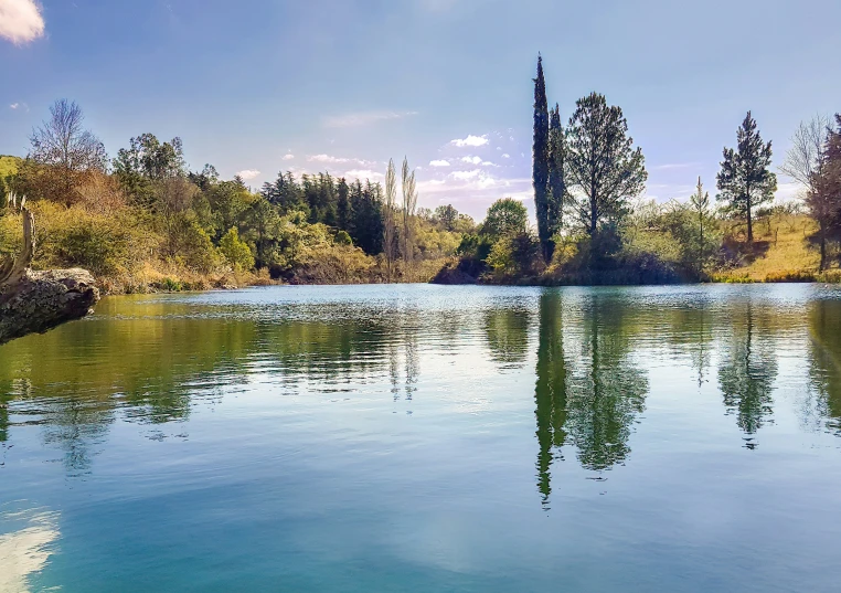 blue water is in front of a tower and trees