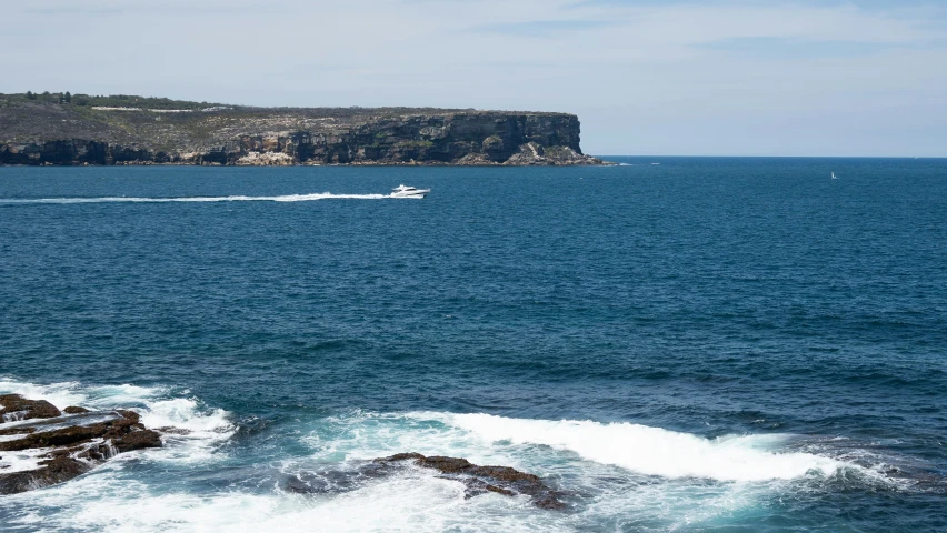 the large boat is making its way out on the blue ocean