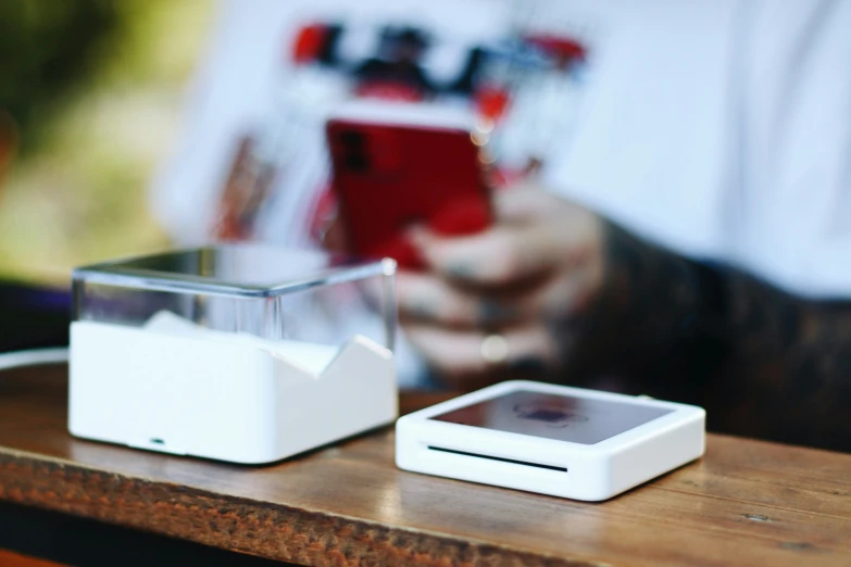 two electronic gadgets sitting on top of a wooden table