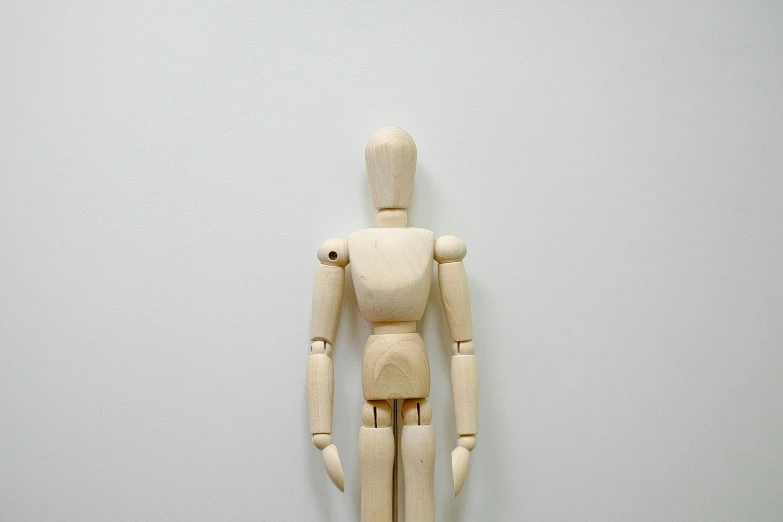 a wooden figure that is posed to be wearing a protective cover