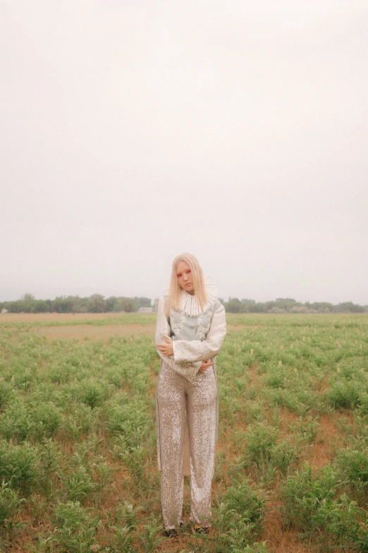 a woman is standing in a green field