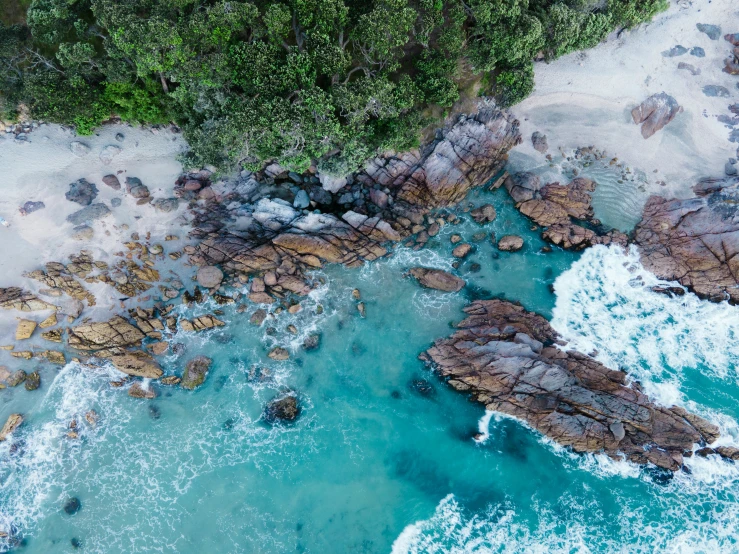 the water next to an island with rocks and trees