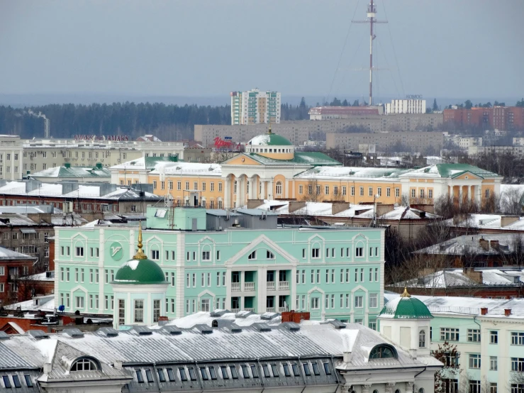 a green building next to buildings on a street