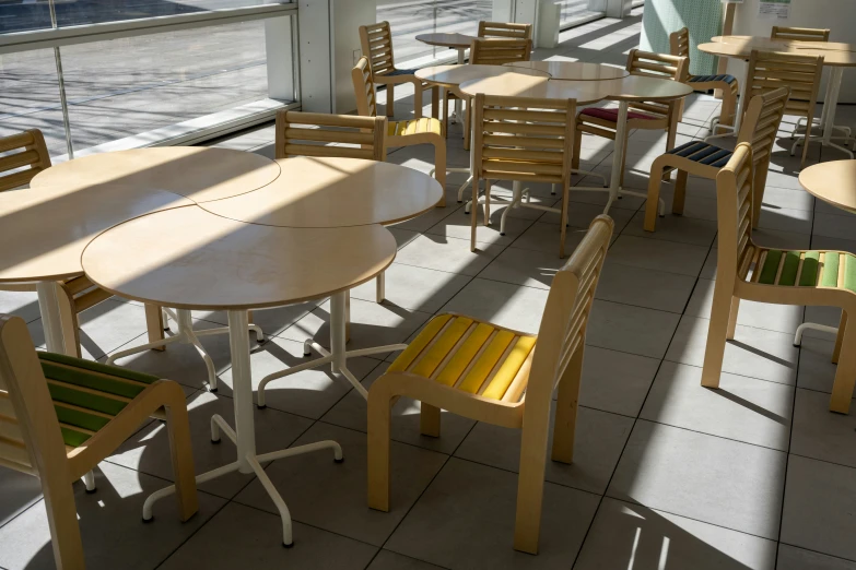 chairs and tables in a room with big windows