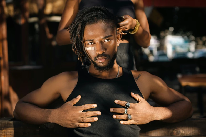 a man with dreadlocks holding his arms in front of his body