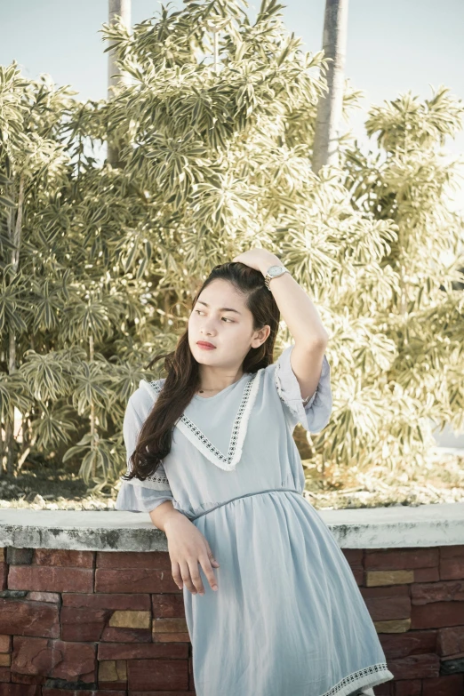 the girl is leaning against the brick wall