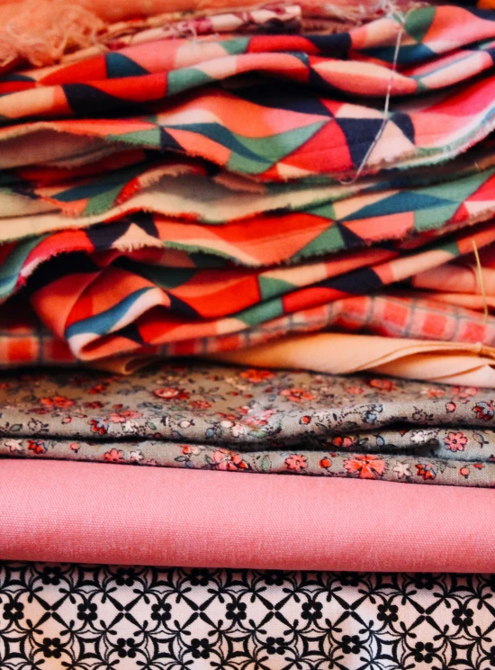 a variety of patterns and fabrics sitting on top of each other