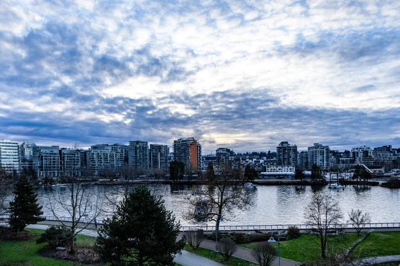 clouds move in over a large lake and city buildings