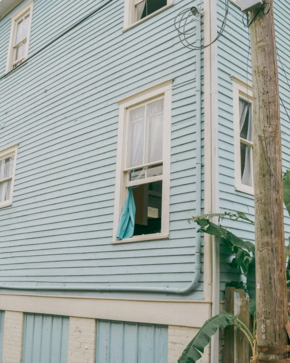 an old house that has a curtained window on it