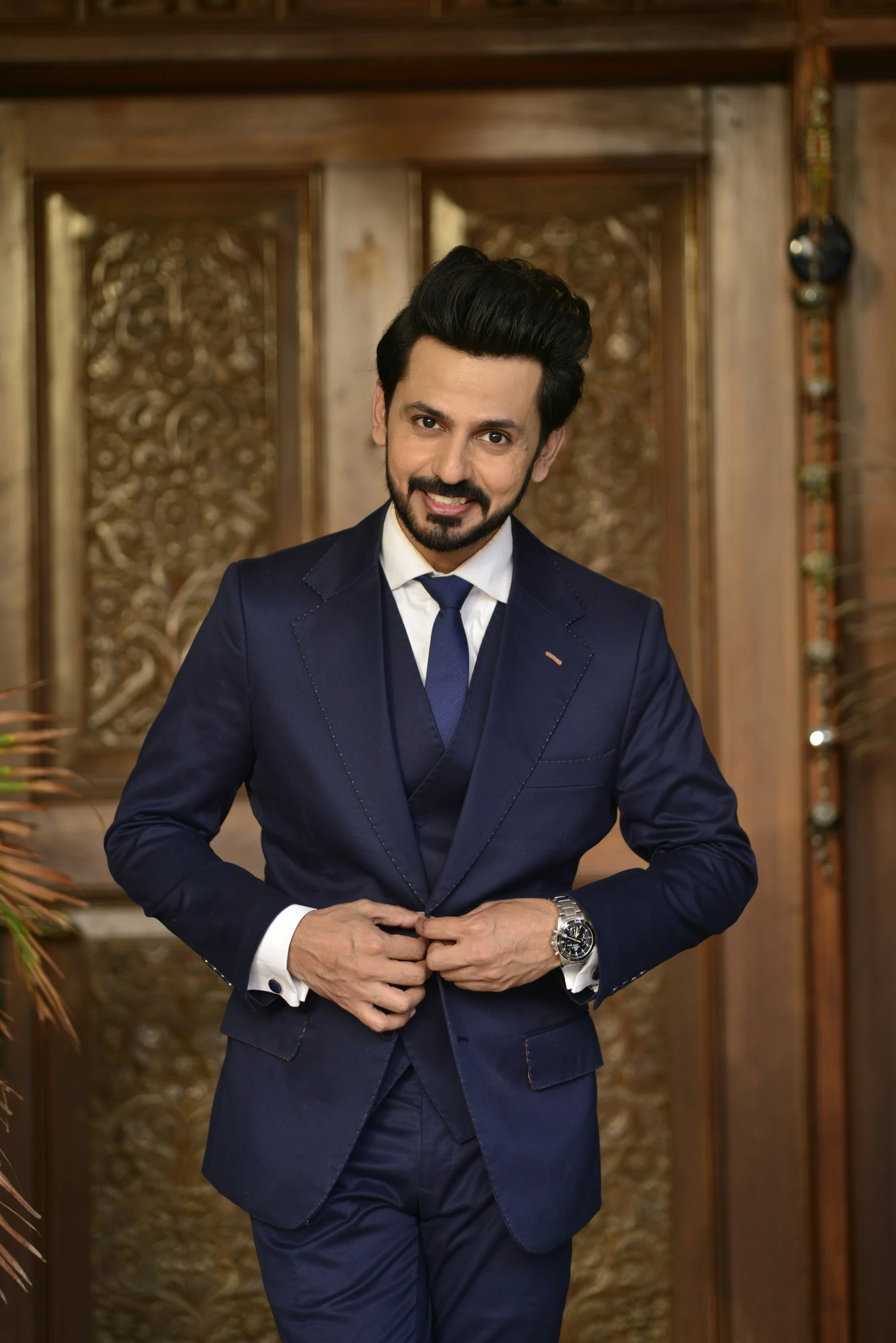 a man in a suit standing in front of an entry door