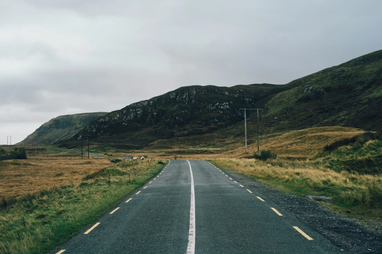 an empty road through the middle of some mountain range